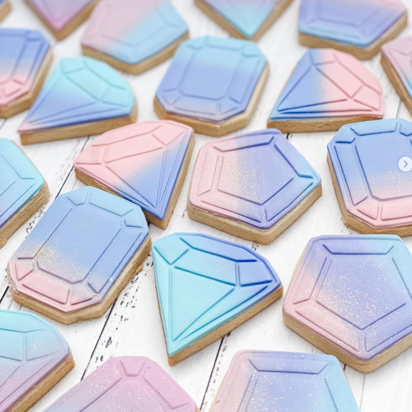 A collection of geometric-shaped cookies in pastel colors, arranged on a surface.