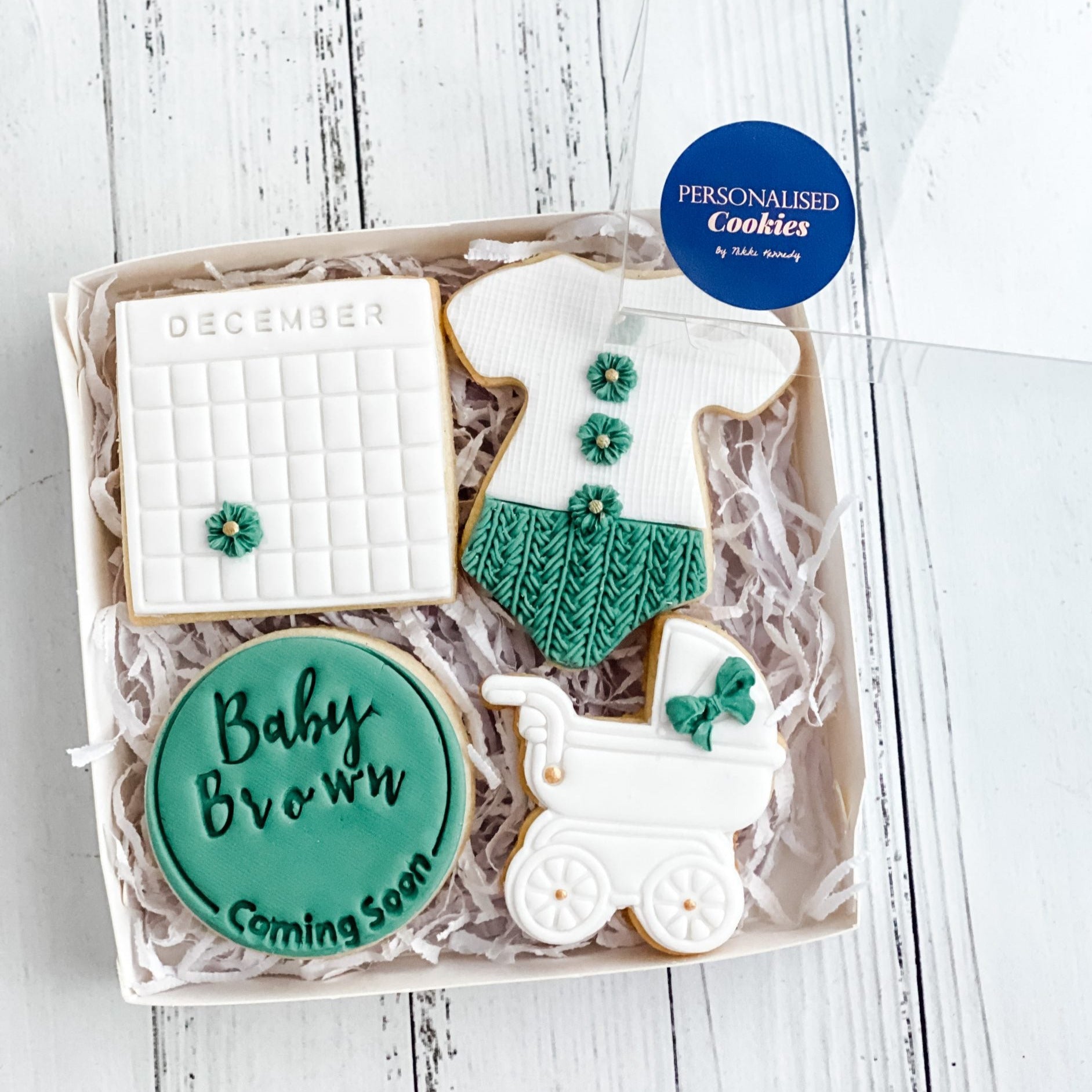 baby shower gift pack in green and white on a white wooden background.