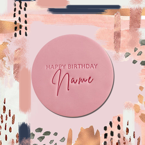 pink round sugar cookie embossed with happy birthday and name